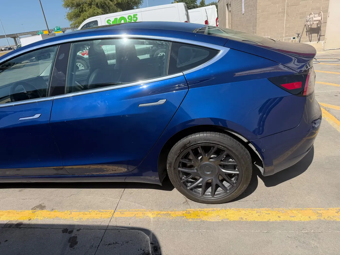 Blue Tesla Model 3 with a new tire mounted on site during a mobile tire replacement in Dallas-Fort Worth