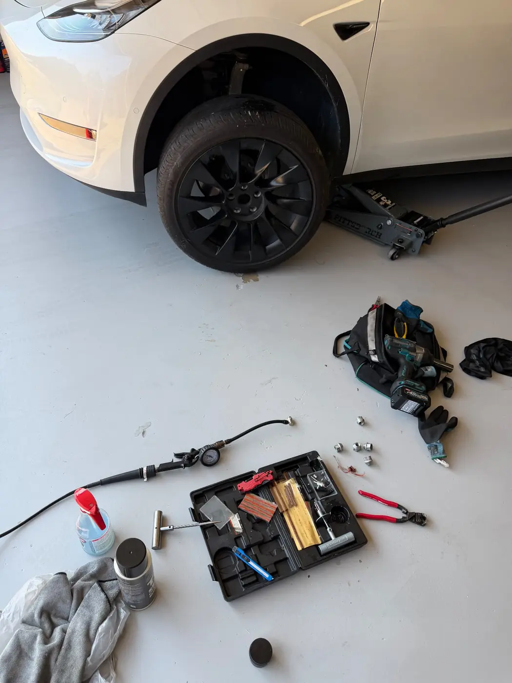 Tire plug being installed in the tread of a Tesla Model Y tire during a mobile puncture repair in Dallas-Fort Worth.