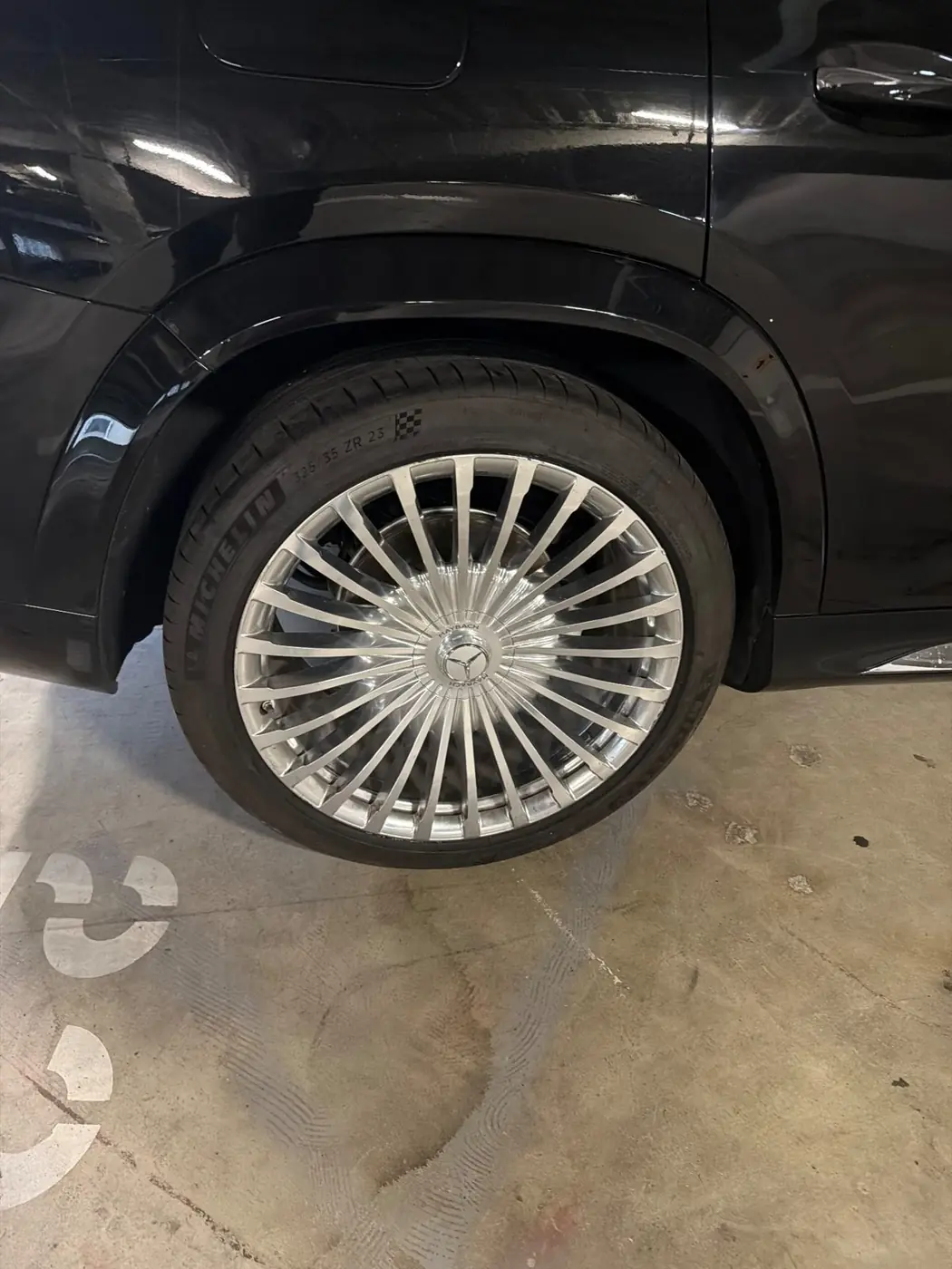 Michelin 325/35 ZR23 tire on a polished 23-inch Mercedes-Maybach wheel during a mobile luxury tire replacement in a Dallas, Texas parking garage.