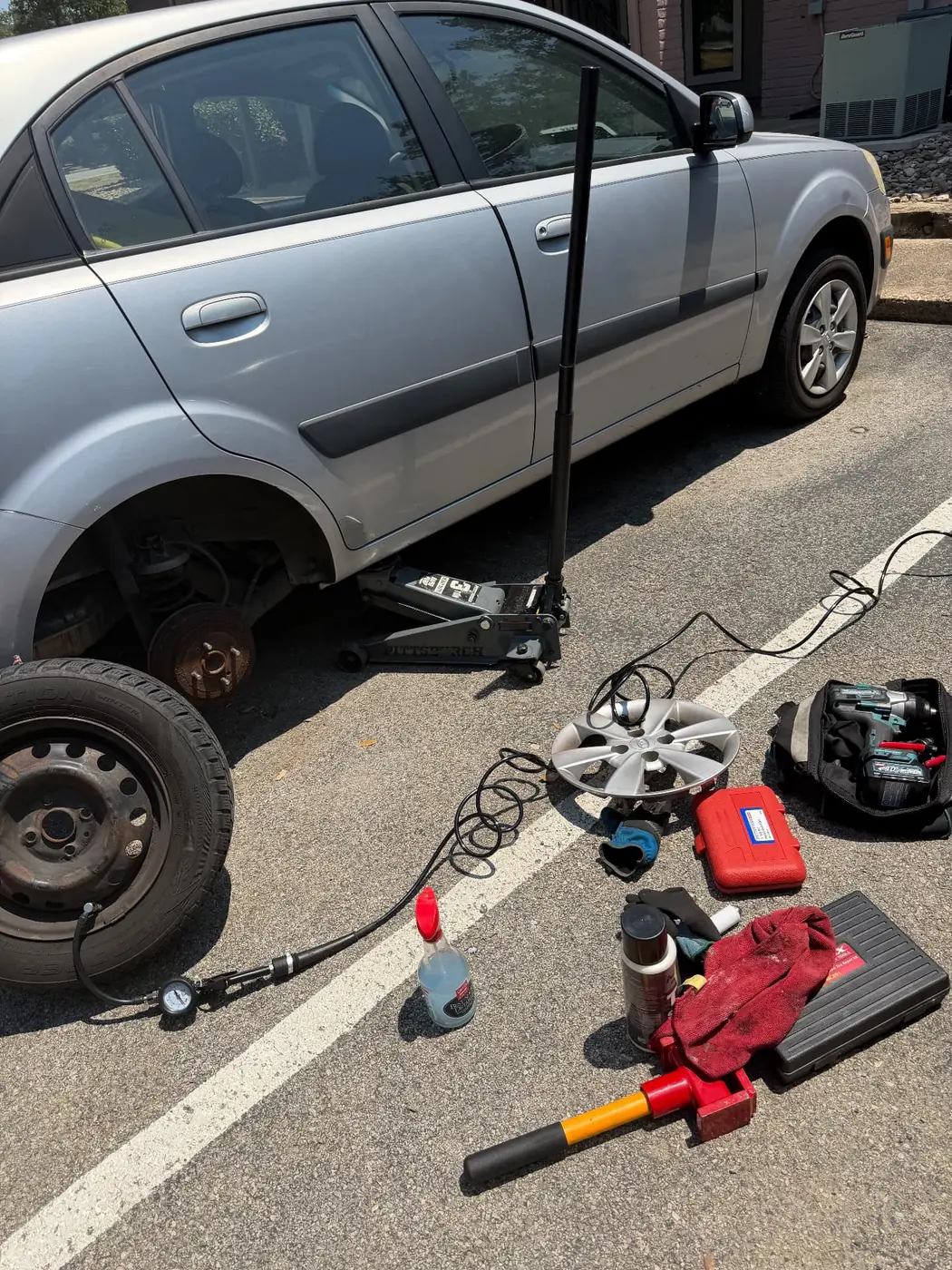 Kia Rio with the compact spare mounted after a mobile flat tire change in Dallas-Fort Worth.