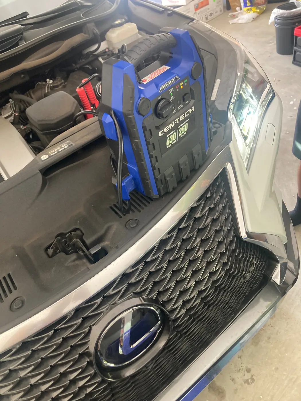 Cen-Tech jump pack connected to a Lexus battery during a mobile jump start in Frisco, Texas.