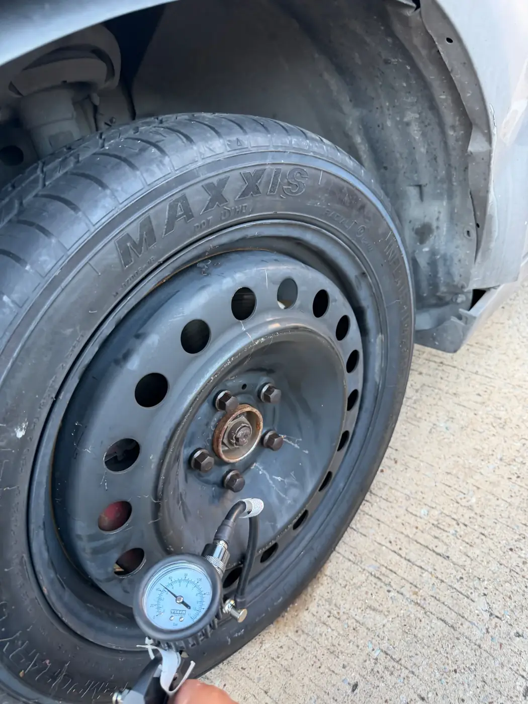 Calibrated tire pressure gauge being used for a final pressure check after a mobile tire service in Dallas-Fort Worth.